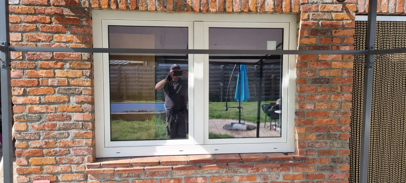 Modern wit raam in rode bakstenen gevel