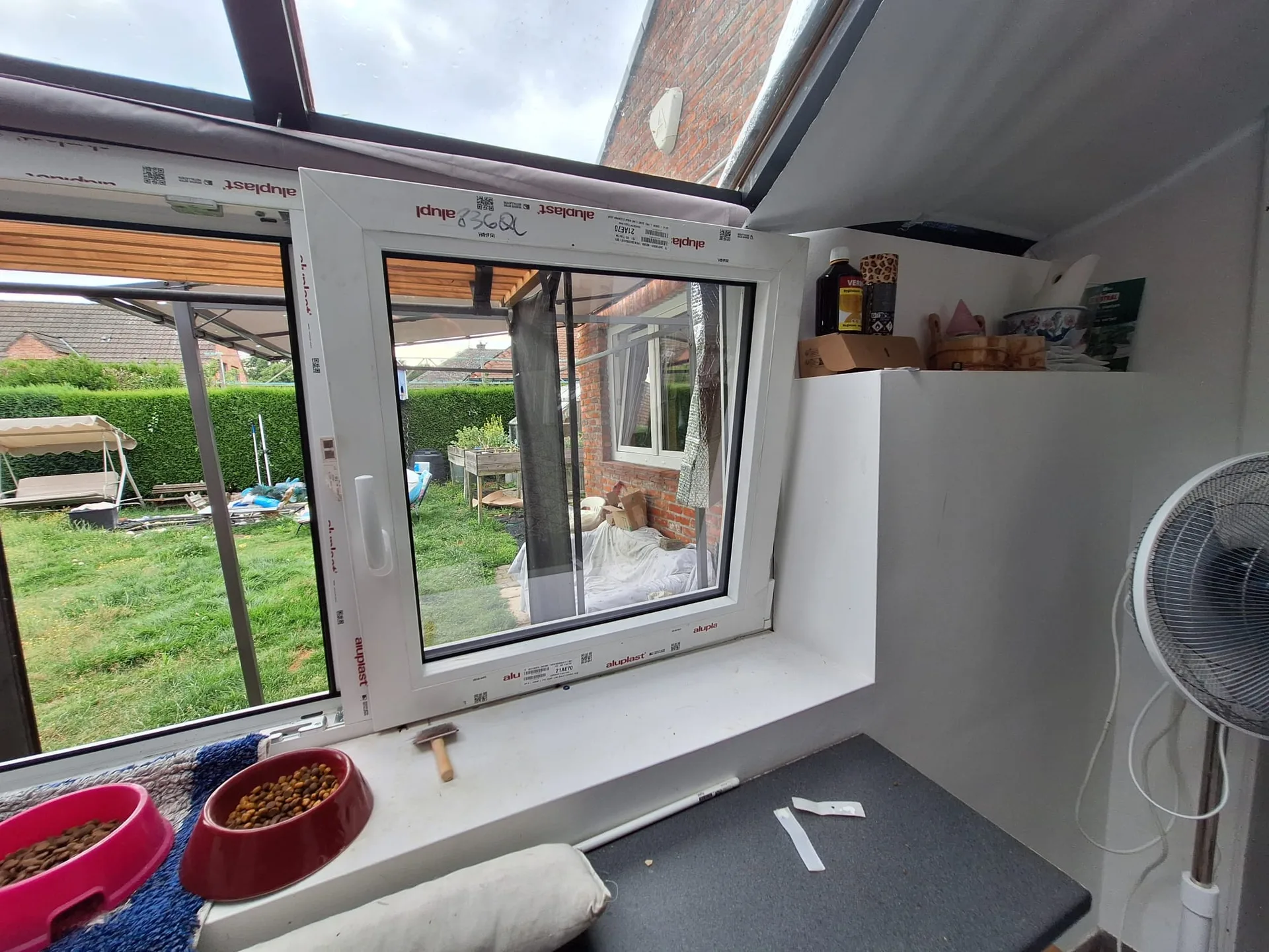 Witte schuiframen van PVC geïnstalleerd in woonkamer met uitzicht op tuin