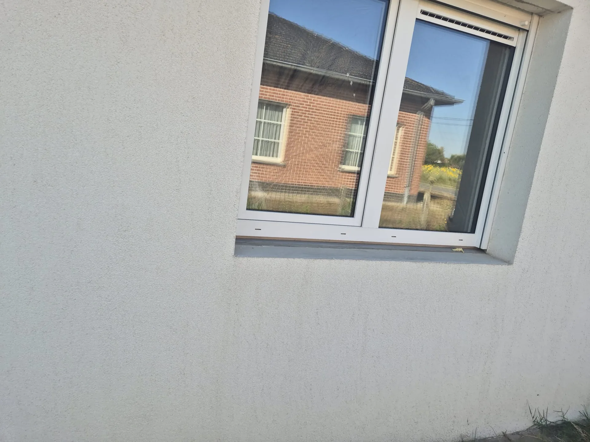 Witte PVC ramen met buitenvensterbank in gevelfasade