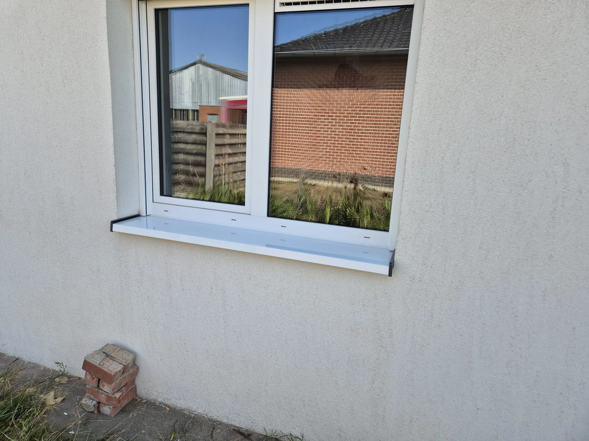 Nieuwe dubbel beglazing in wit PVC met volledige afwerking en pleistering rondom