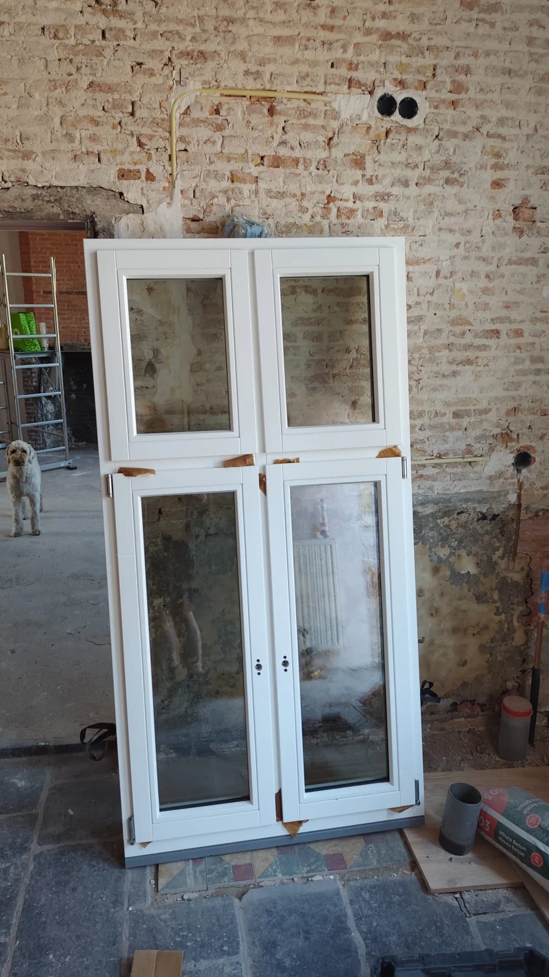 Witte houten voordeuren met vier beglaside ramen en houtwerk afwerking