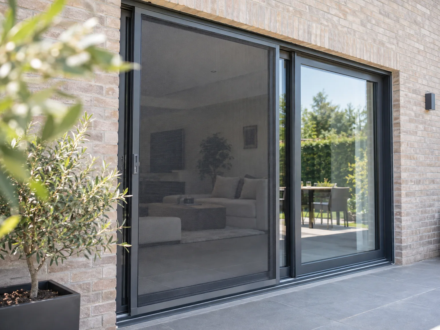 Grote aluminium schuiframen in zwart met uitzicht op tuin en terras