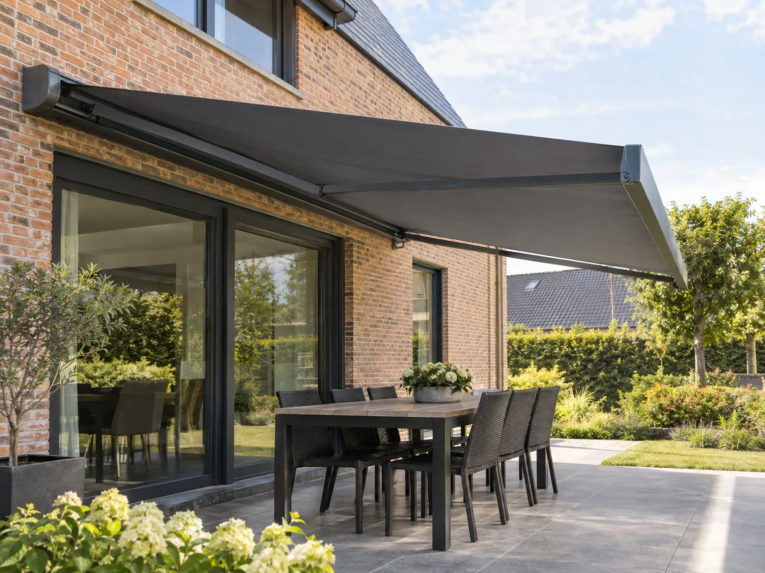 Terras met grote zwarte schuiframen en zonwering