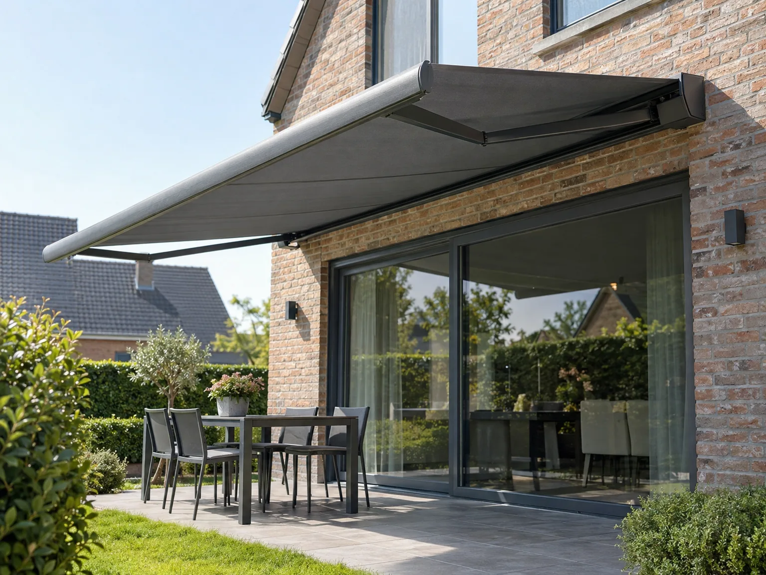 Schuiframen en zonwering op een bakstenen terras van woning