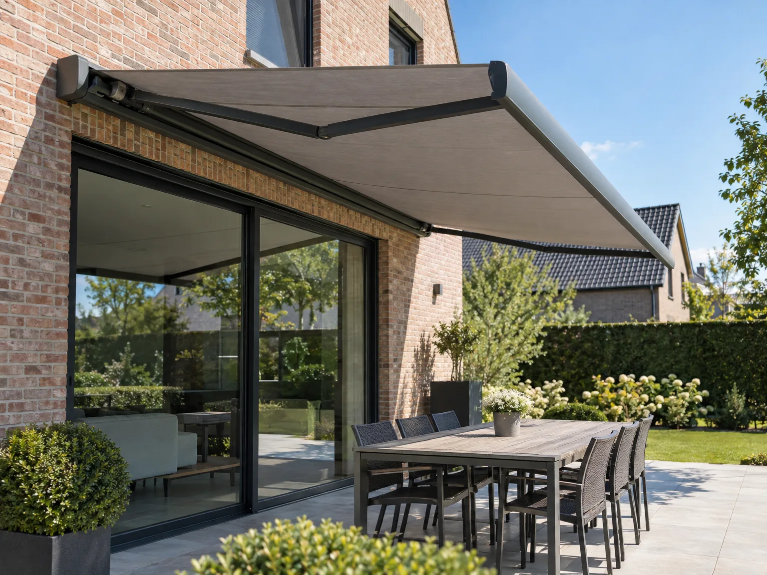 Grote schuiframen met screens op terras bij moderne bakstenen woning